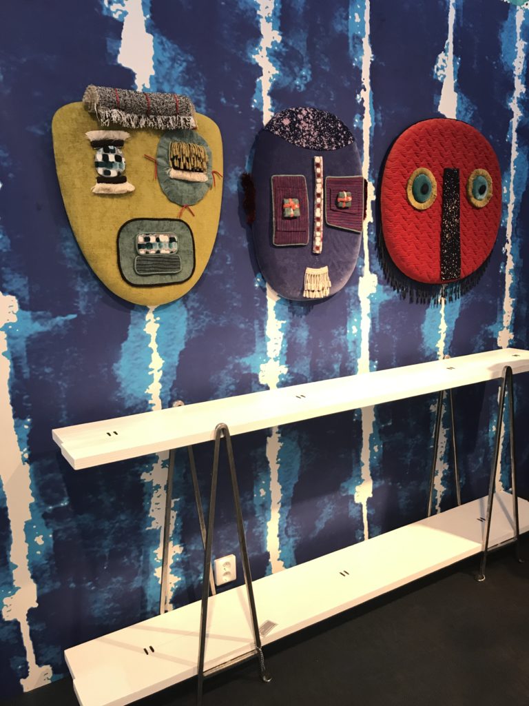 מסיכות עשויות טקסטיל מעל שידת מדפים עשויה עץ וברזל בעיצוב פאולה נבונה. צילמה: עדי אדליס